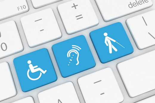 Foto colorida mostra um teclado com teclas brancas. No lugar de letras, o teclado traz três teclas azuis com os símbolos: deficiência física, deficiência auditiva e deficiência visual.